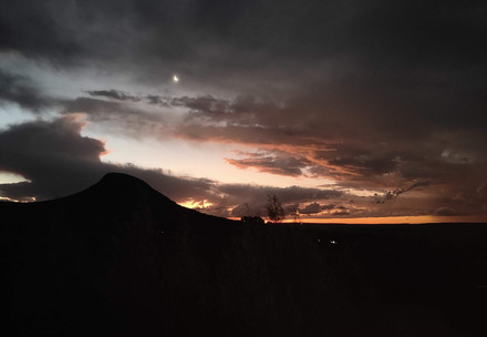 Cloudy sky silhouetted against hills